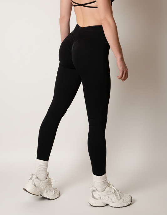 Black high-waisted seamless scrunch-butt leggings with a wide waistband and subtle "SQWT" logo on the hip, shown from both side and back views.
