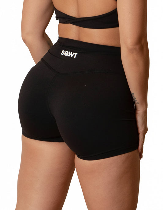 Black seamless high-waist shorts with flattering V-shaped crossover waistband, best for women's studio sessions, yoga, and athleisure.
