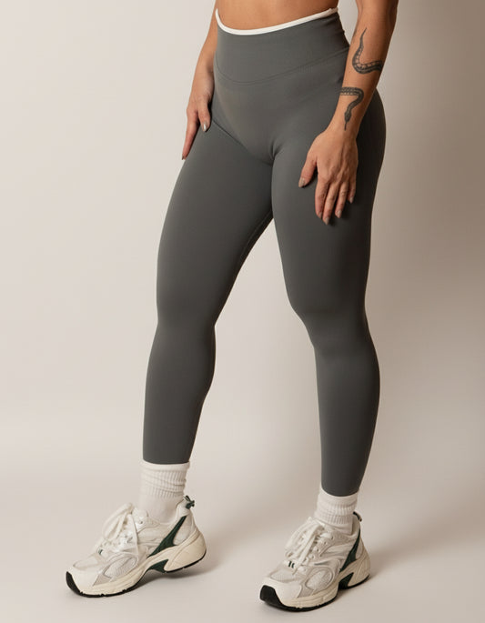 Dark grey seamless leggings with white piping featuring a supportive high waist, invisible scrunch butt, and butt lifting compression, perfect for gym, squat proof workouts, and fitness.
