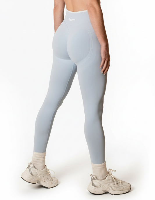 Baby blue seamless leggings with white piping featuring a supportive high waist, invisible scrunch butt, and butt lifting compression, perfect for gym, squat proof workouts, and fitness.