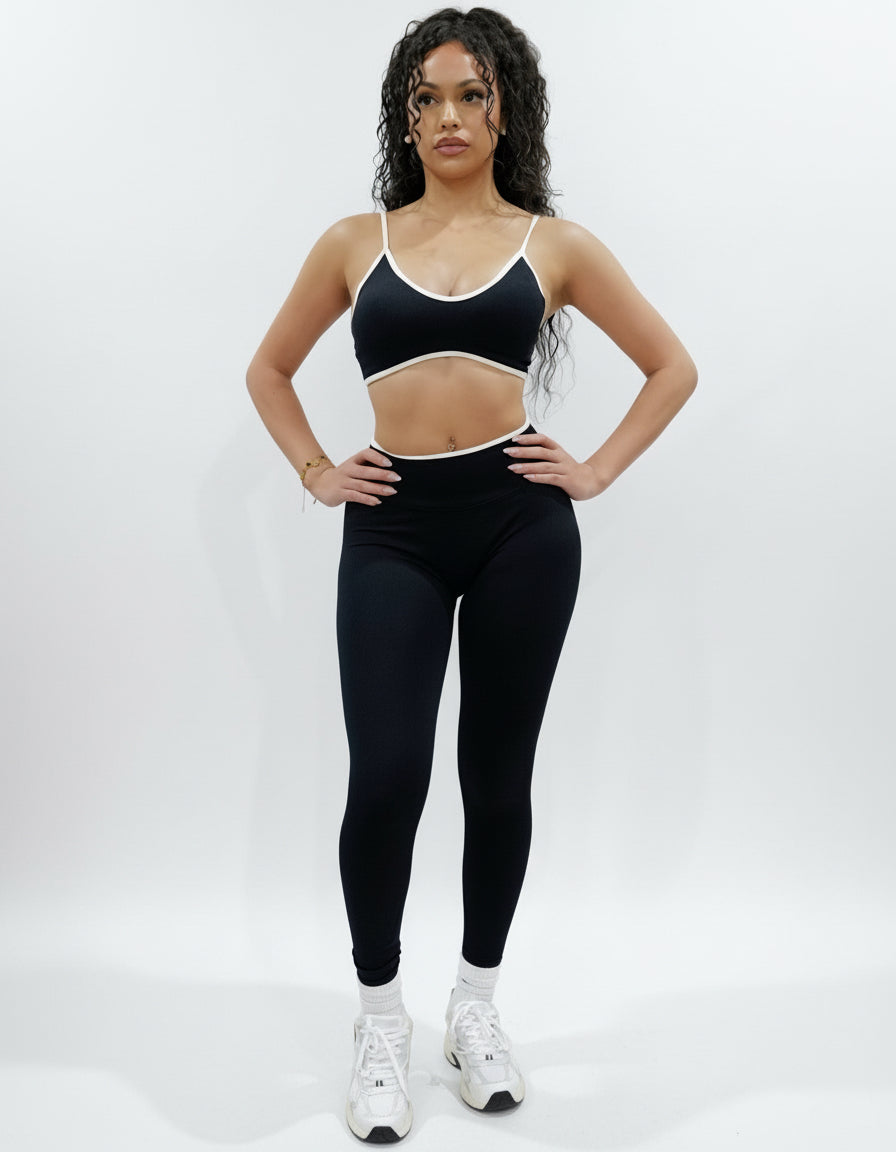 Black seamless leggings with white piping featuring a supportive high waist, invisible scrunch butt, and butt lifting compression, perfect for gym, squat proof workouts, and fitness.