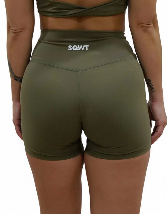 Olive green seamless high-waist shorts with flattering V-shaped crossover waistband, best for women's studio sessions, yoga, and athleisure.
