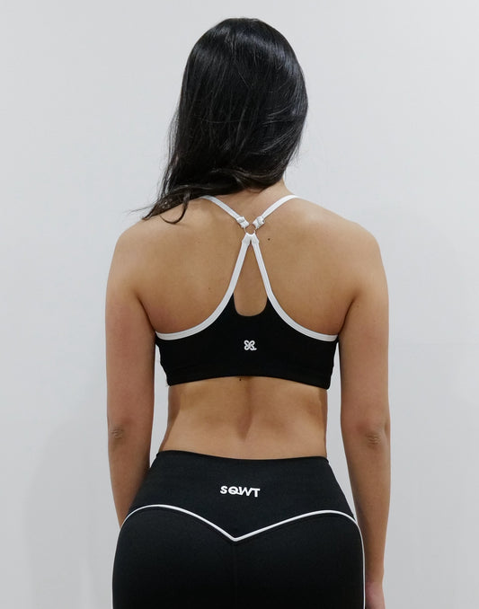 SQWT ContourHeart Bra in Black, a light-compression workout bra for women with white trim, scoop neck, and unique Y-back strap design for yoga, Pilates, and everyday comfort.