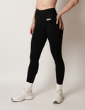 Black high-waisted seamless scrunch-butt leggings with a wide waistband and subtle "SQWT" logo on the hip, shown from both side and back views.