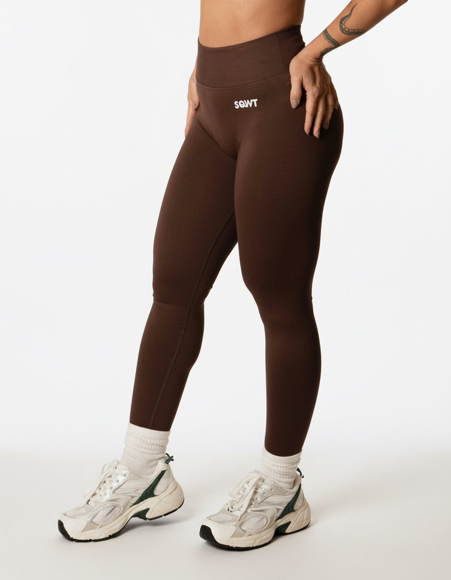 Dark brown high-waisted seamless scrunch-butt leggings with a wide waistband and subtle "SQWT" logo on the hip, shown from both side and back views.