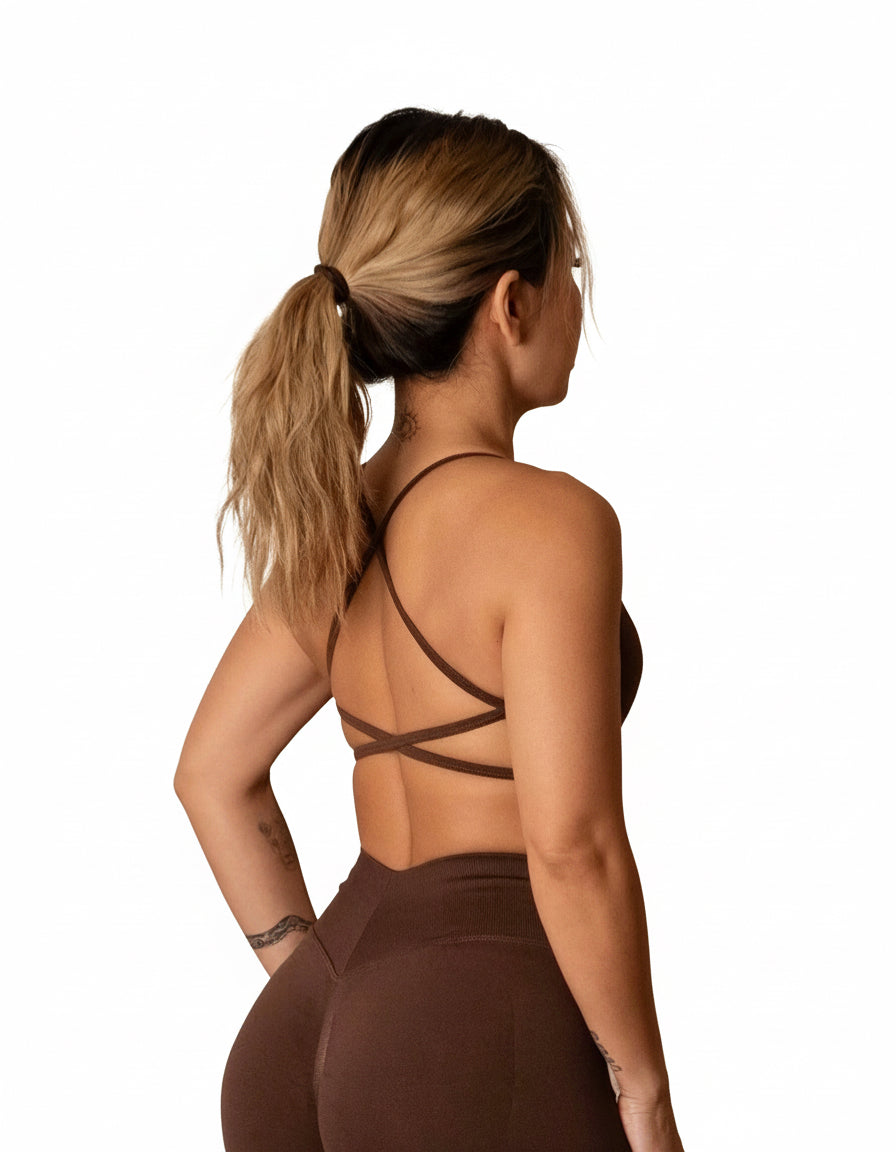 Dark brown sports bra with thin straps, featuring a cross-back design and supportive front fit, shown on a model from both front and back.