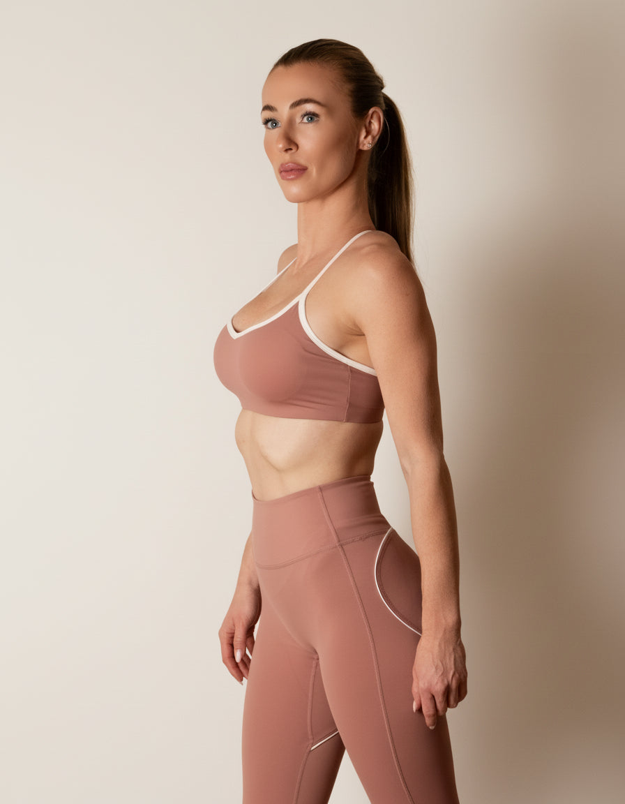 SQWT ContourHeart  Bra in dusty pink, a light-compression workout bra for women with white trim, scoop neck, and unique Y-back strap design for yoga, Pilates, and everyday comfort.