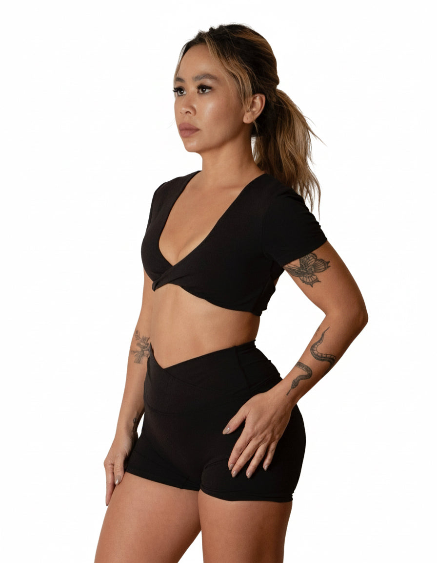 Black seamless high-waist shorts with flattering V-shaped crossover waistband, best for women's studio sessions, yoga, and athleisure.
