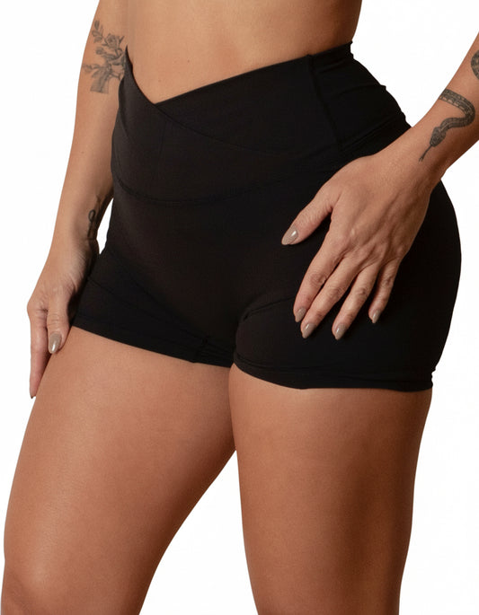 Black seamless high-waist shorts with flattering V-shaped crossover waistband, best for women's studio sessions, yoga, and athleisure.