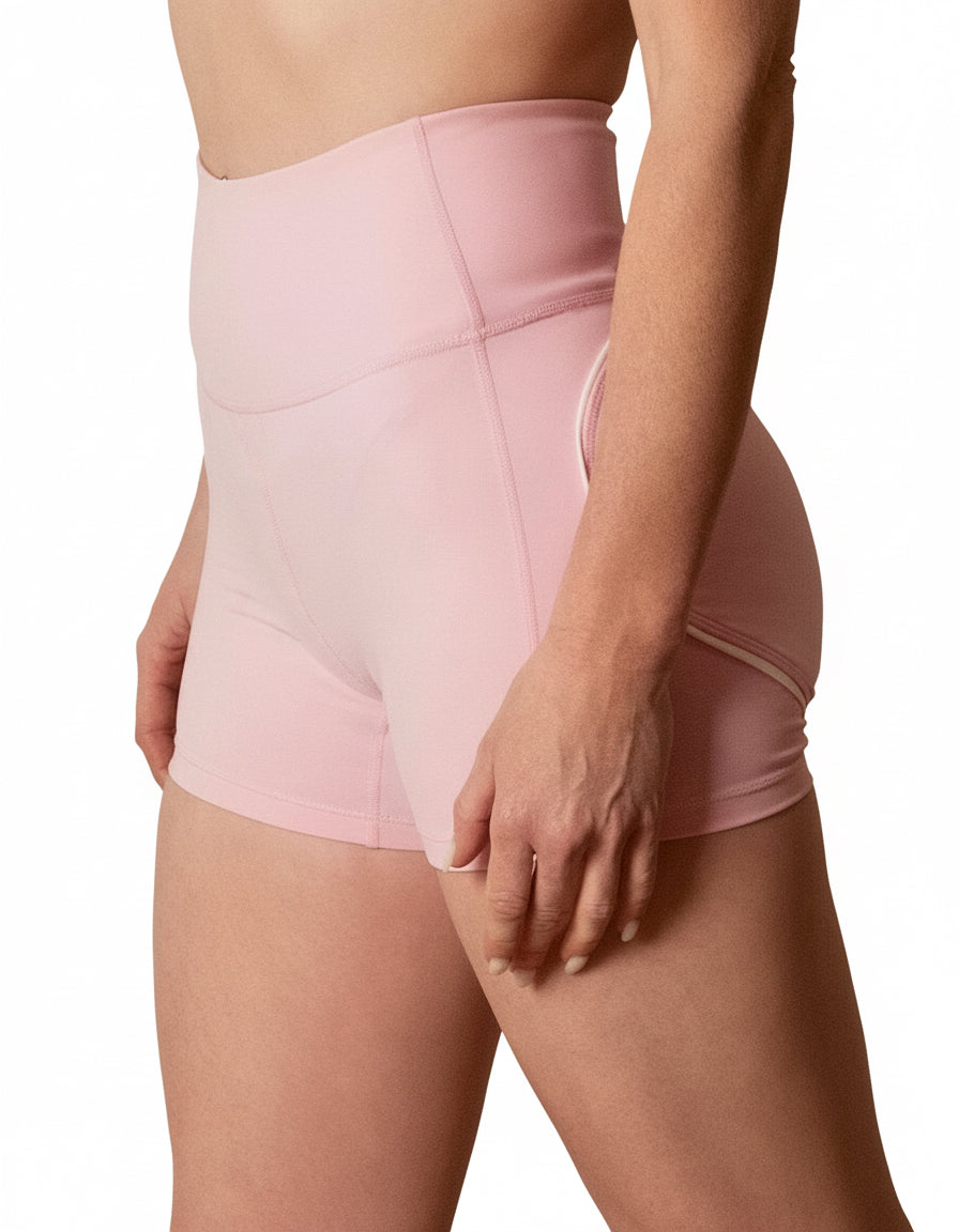 Seamless high-waisted gym shorts in baby pink, featuring a wide V-shaped back waistband with white contrast piping/seaming that enhances the booty shape.