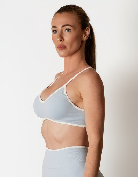 SQWT seamless baby blue sports bra with white contrast for women. Medium support gym bra designed to lift and enhance breasts. Ideal for workouts
