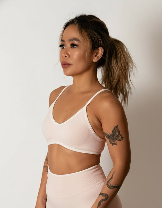 SQWT seamless baby pink sports bra with white contrast for women. Medium support gym bra designed to lift and enhance breasts. Ideal for workouts