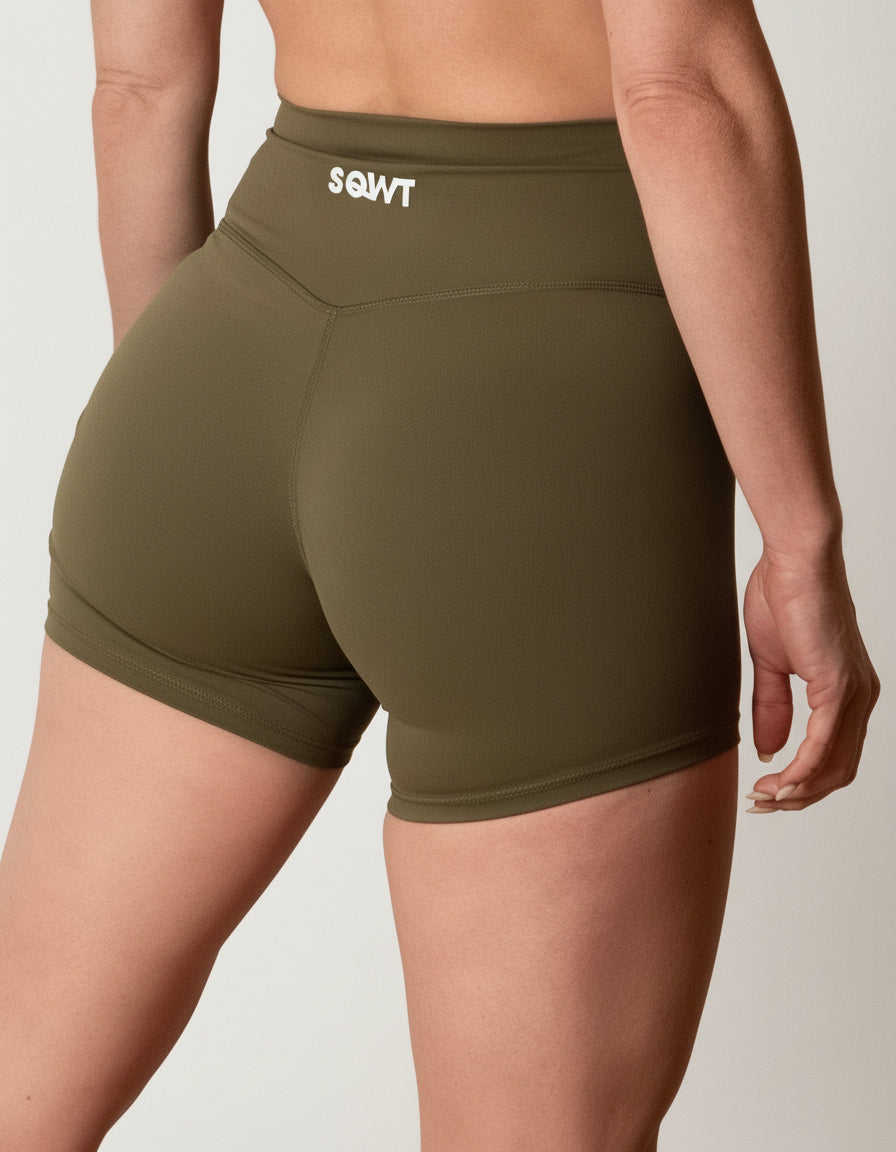 Olive green seamless high-waist shorts with flattering V-shaped crossover waistband, best for women's studio sessions, yoga, and athleisure.