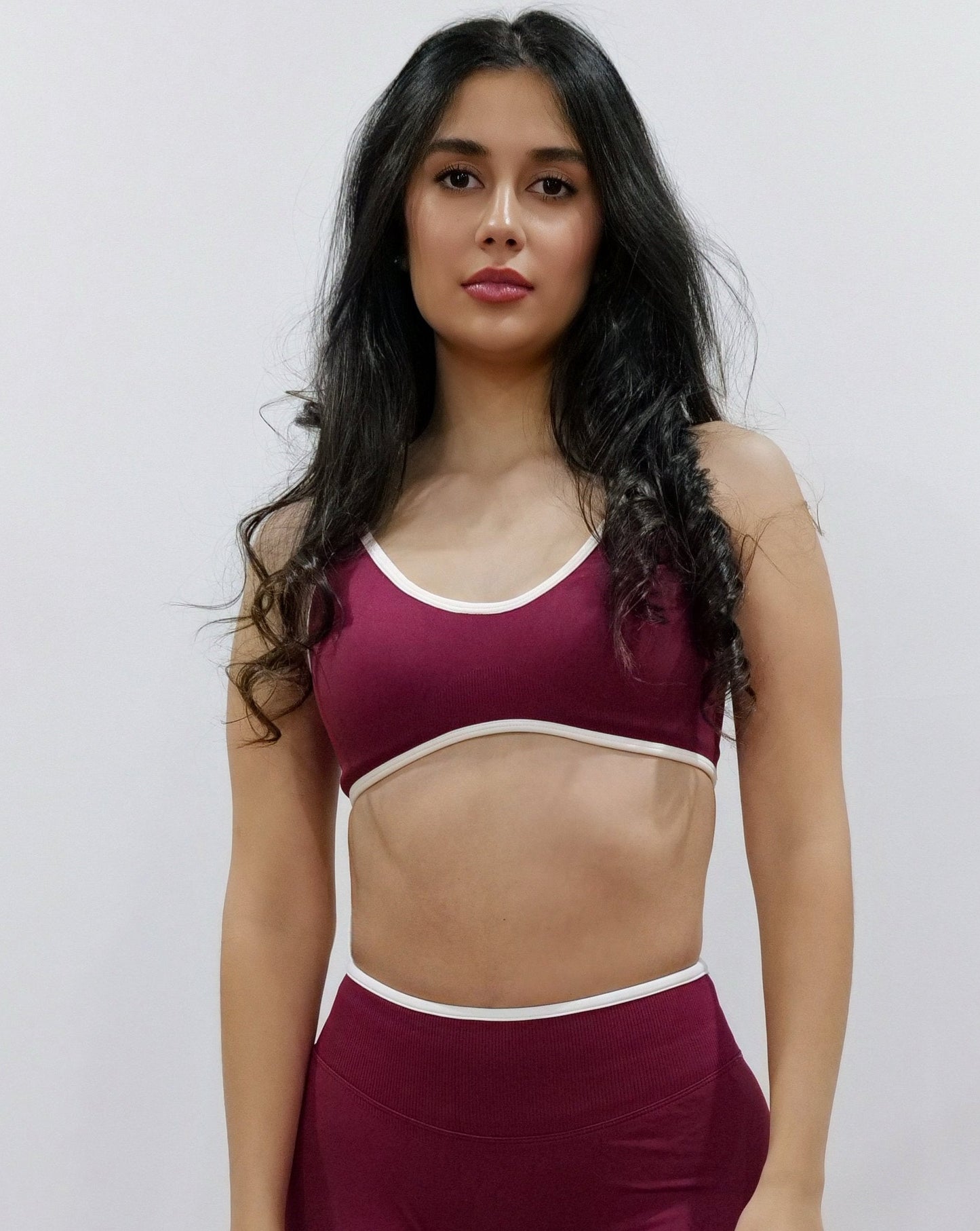 SQWT seamless red wine sports bra with white contrast for women. Medium support gym bra designed to lift and enhance breasts. Ideal for workouts