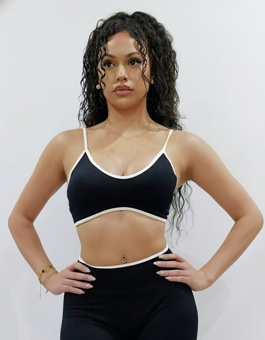 SQWT seamless black sports bra with white contrast for women. Medium support gym bra designed to lift and enhance breasts. Ideal for workouts