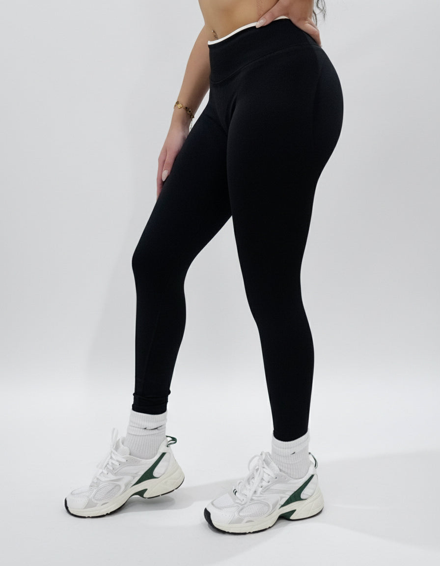 Black seamless leggings with white piping featuring a supportive high waist, invisible scrunch butt, and butt lifting compression, perfect for gym, squat proof workouts, and fitness.