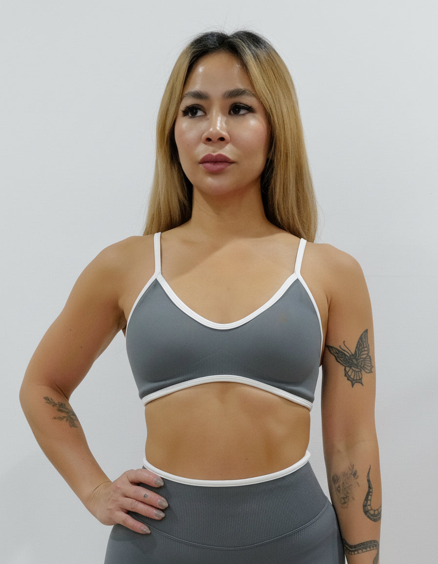 SQWT seamless dark grey sports bra with white contrast for women. Medium support gym bra designed to lift and enhance breasts. Ideal for workouts