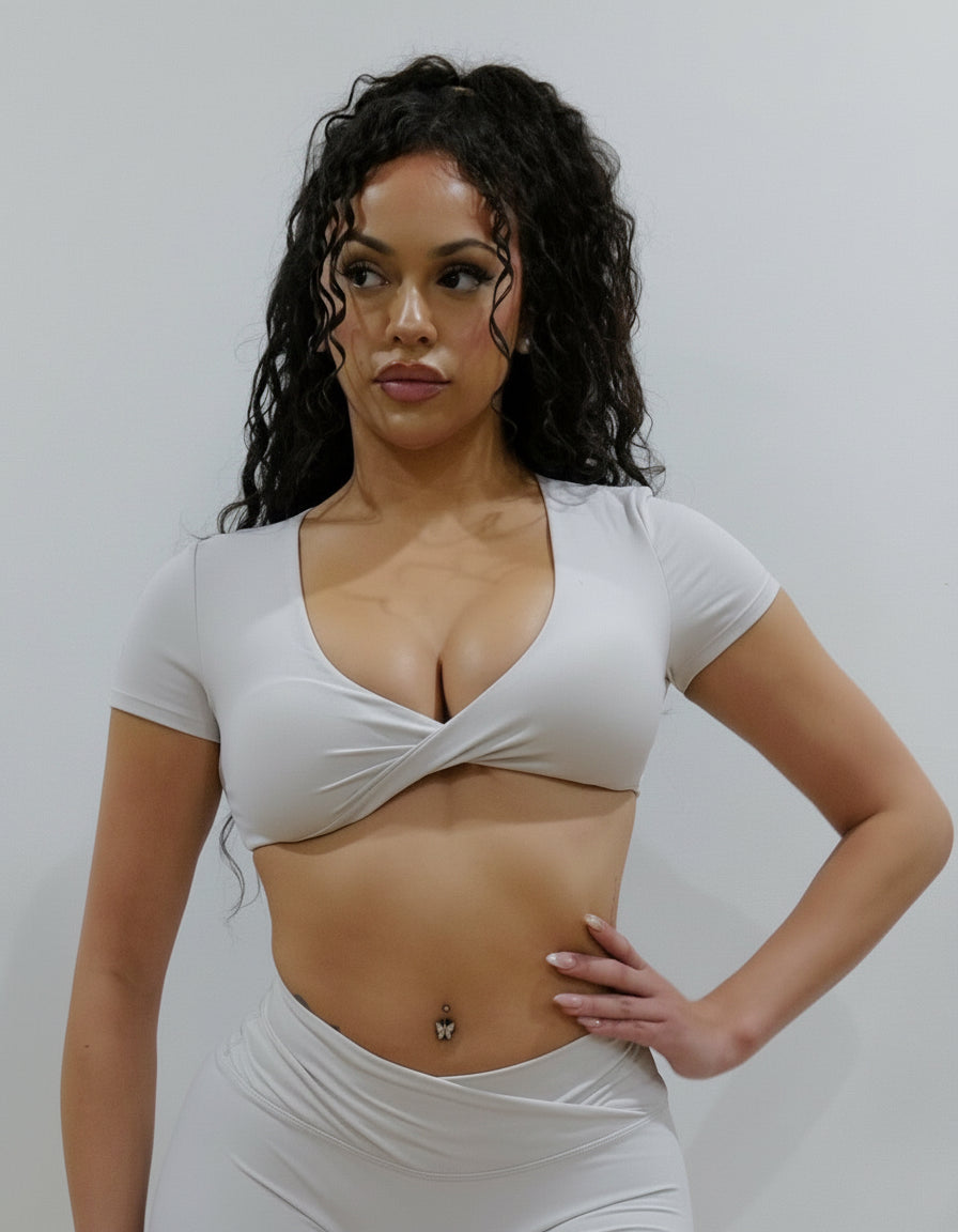Sand colour short-sleeve crop top/bra top with a twisted knot front and back, open cut-out back, and a deep V-neckline. Ideal for women's activewear, gym, and yoga.
