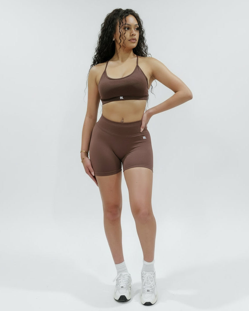 Seamless high-waisted gym shorts in dark brown, featuring a wide V-shaped back waistband and subtle seam detailing designed for an invisible booty lift.