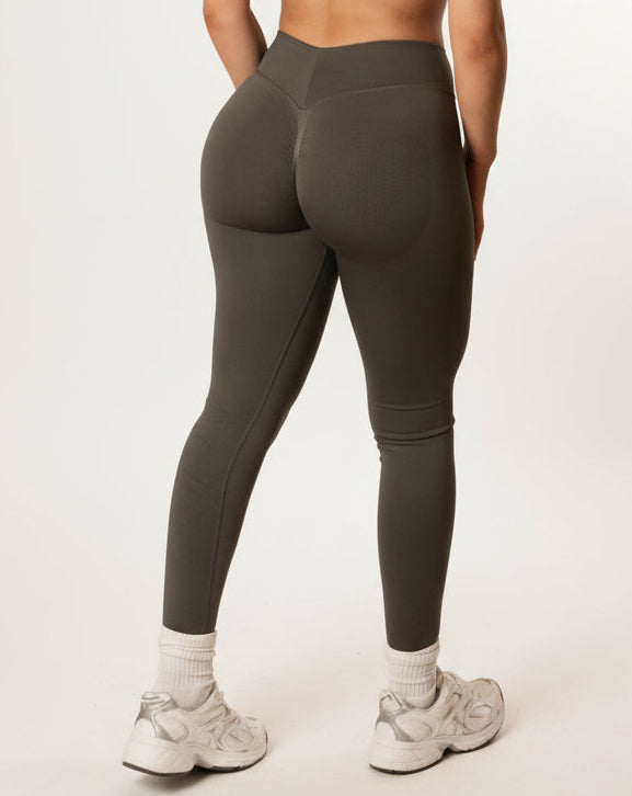 Dark grey high-waisted seamless scrunch-butt leggings with a wide waistband and subtle "SQWT" logo on the hip, shown from both side and back view