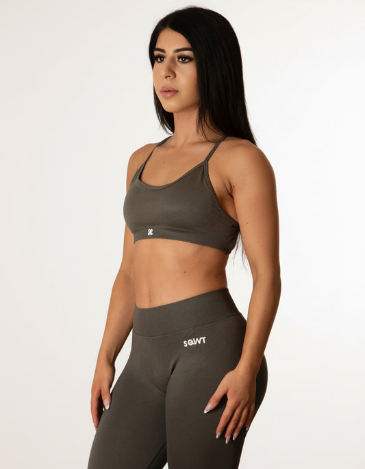 Dark Grey sports bra with thin straps, featuring a cross-back design and supportive front fit, shown on a model from both front and back.