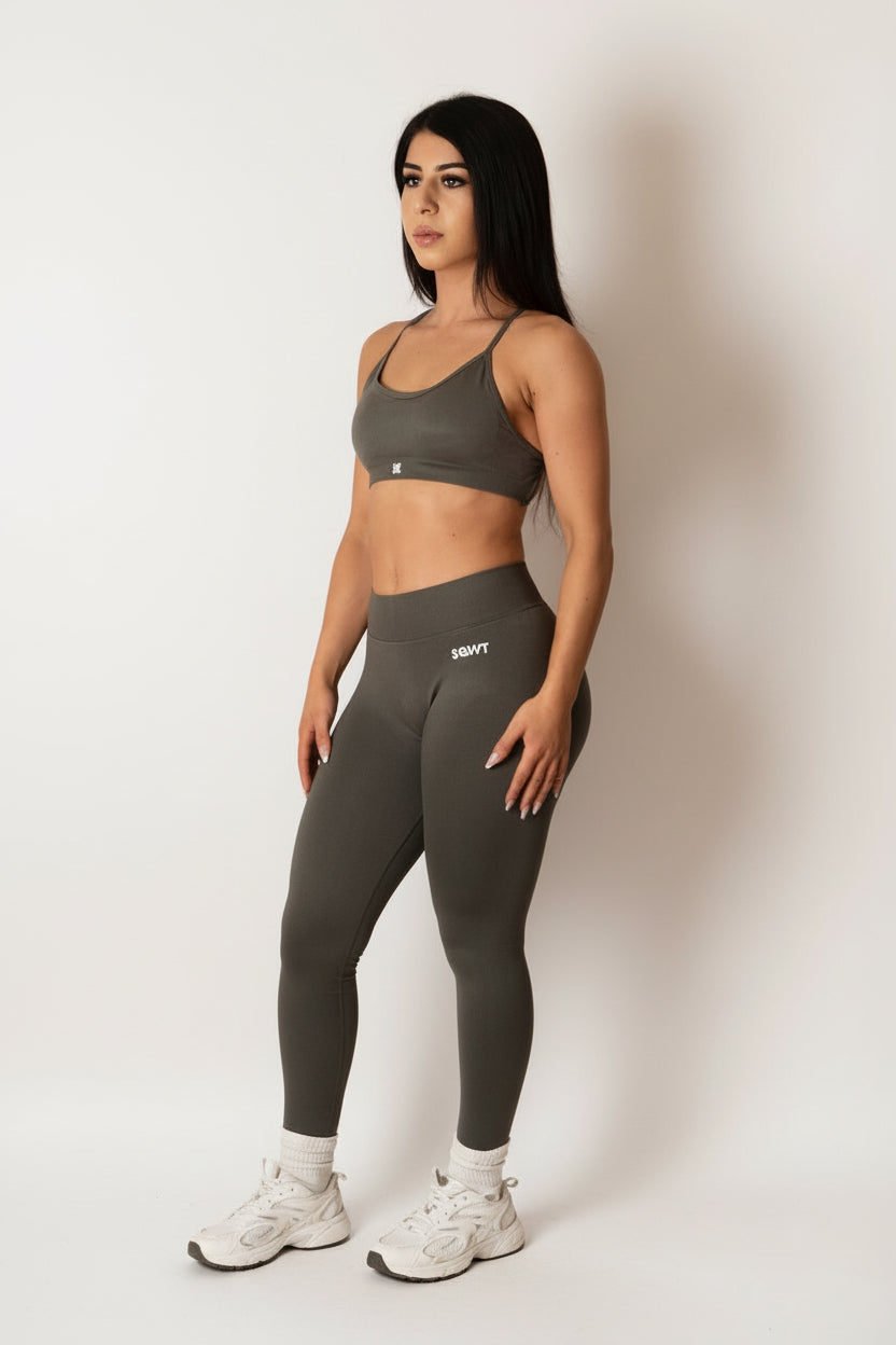 Dark grey high-waisted seamless scrunch-butt leggings with a wide waistband and subtle "SQWT" logo on the hip, shown from both side and back view